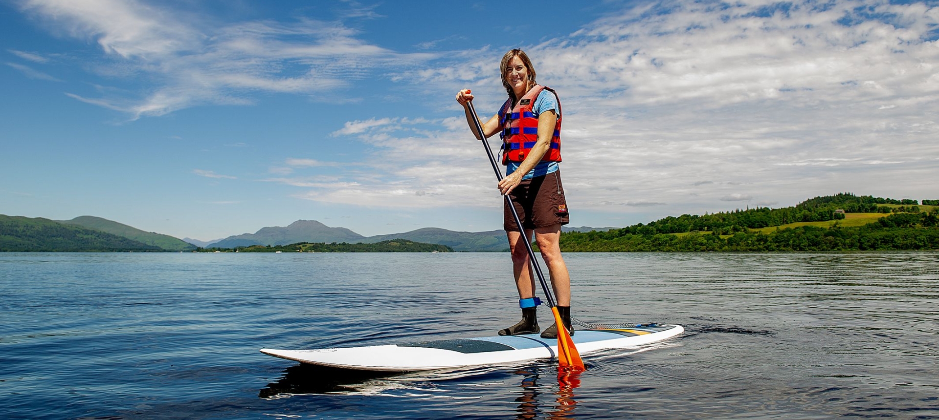 Dame Katherine Grainger standing on a paddle board on Loch Lomond