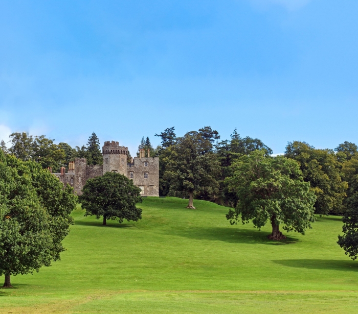 A Scottish castle with a lush green lawn in Balloch Country