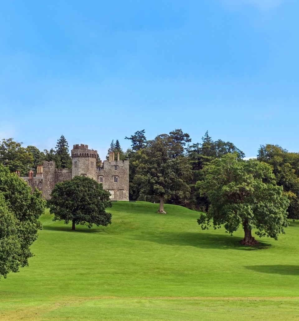 A Scottish castle with a lush green lawn in Balloch Country