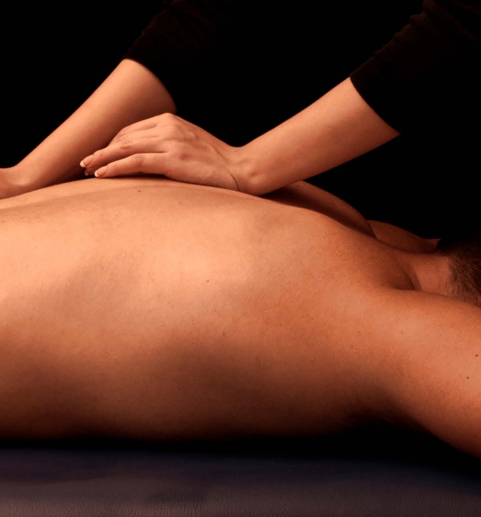 a man laying on a table getting his shoulders and back massaged