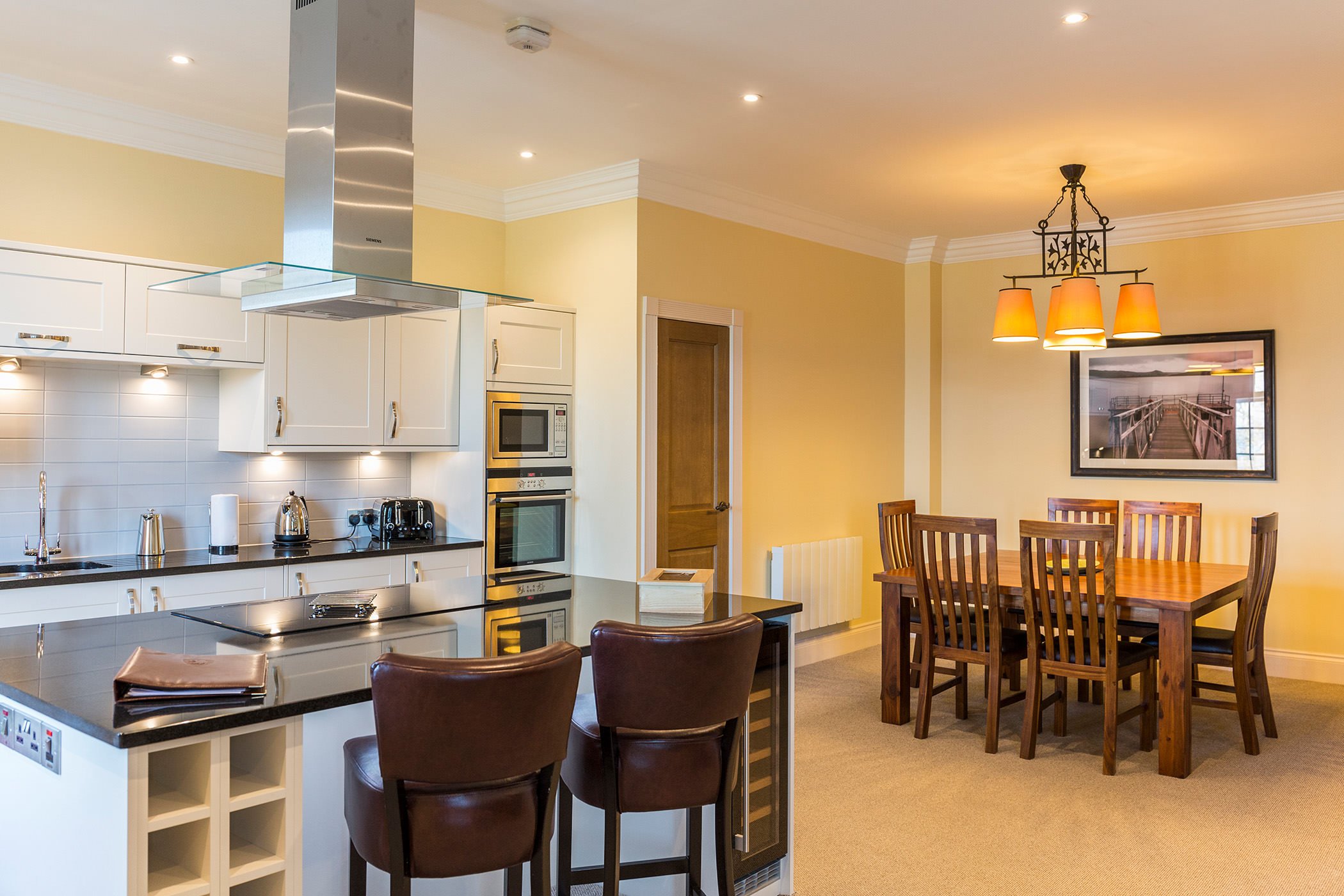 a kitchen area with a dining room table and a central island