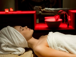 a woman relaxing on a table with red back ground lighting