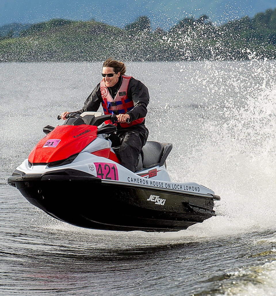 a person riding a red and white jet ski jumping over the waves on the water