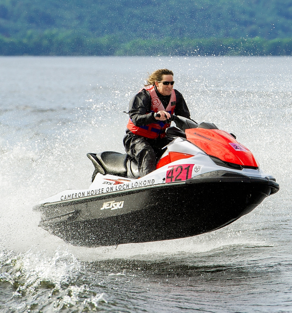 a person riding a white and red jet ski jumping over the waves in the middle of the lake