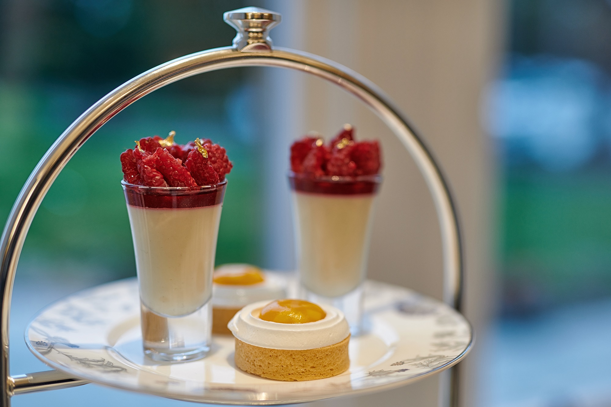 small glasses of raspberries in yogurt sitting next to finger food