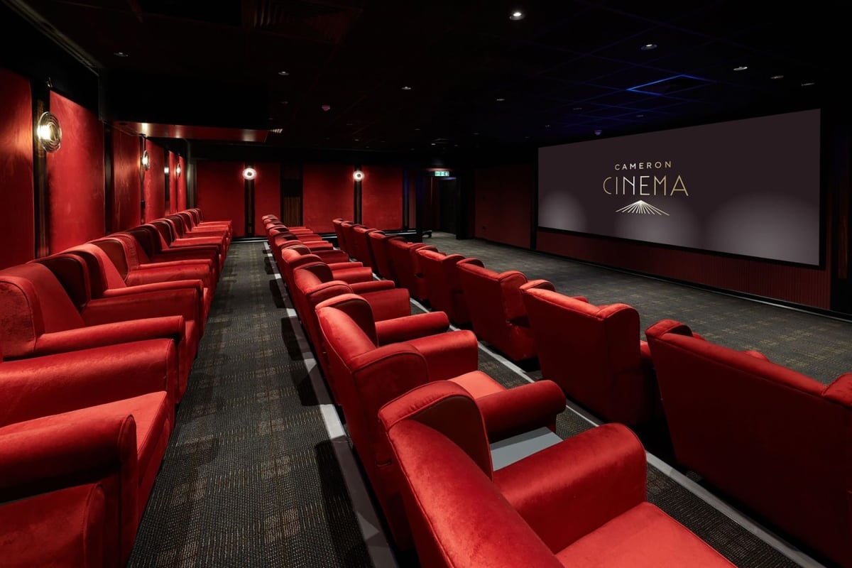 Cameron cinema located in Cameron house with rows of seating available