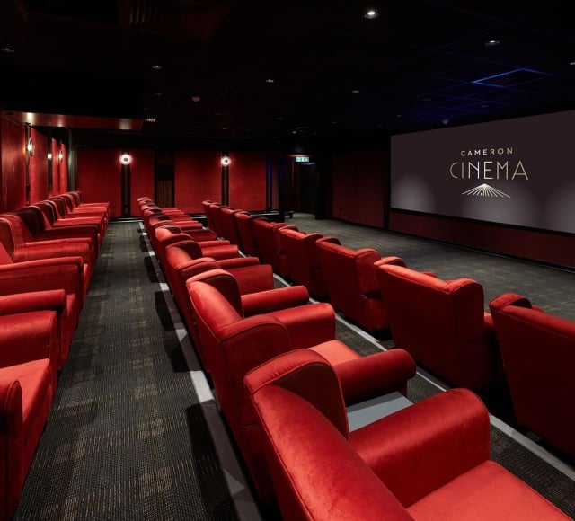 Cameron cinema located in Cameron house with rows of seating available