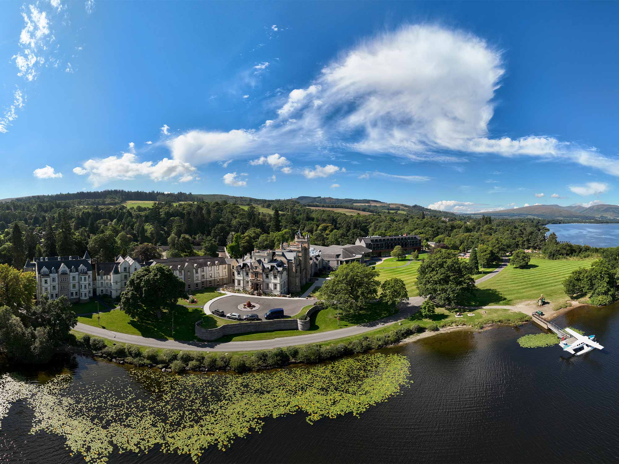 a birds eye view of cameron house showing the water and trees surrounding the property