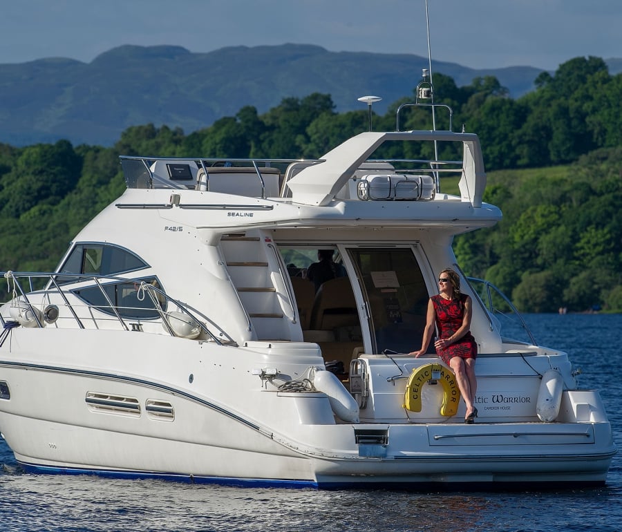 a woman in a dress sitting on a boat in the middle of the water