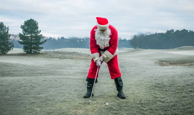 Man in a Santa suit playing golf