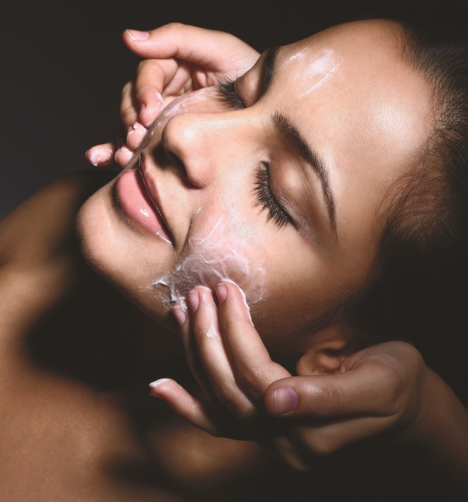 a woman relaxing and getting cream applied to her face