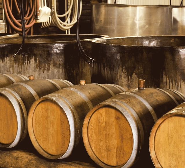 wooden barrels sitting in front of two large brewing pots