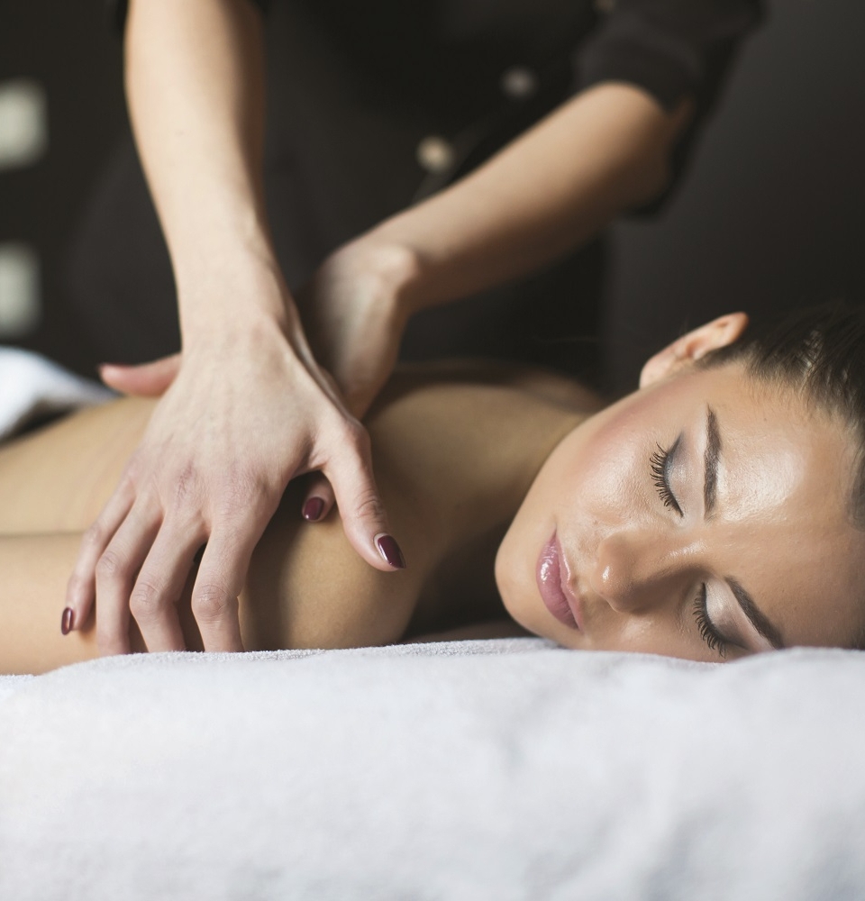 a woman laying on a table getting her shoulder massaged