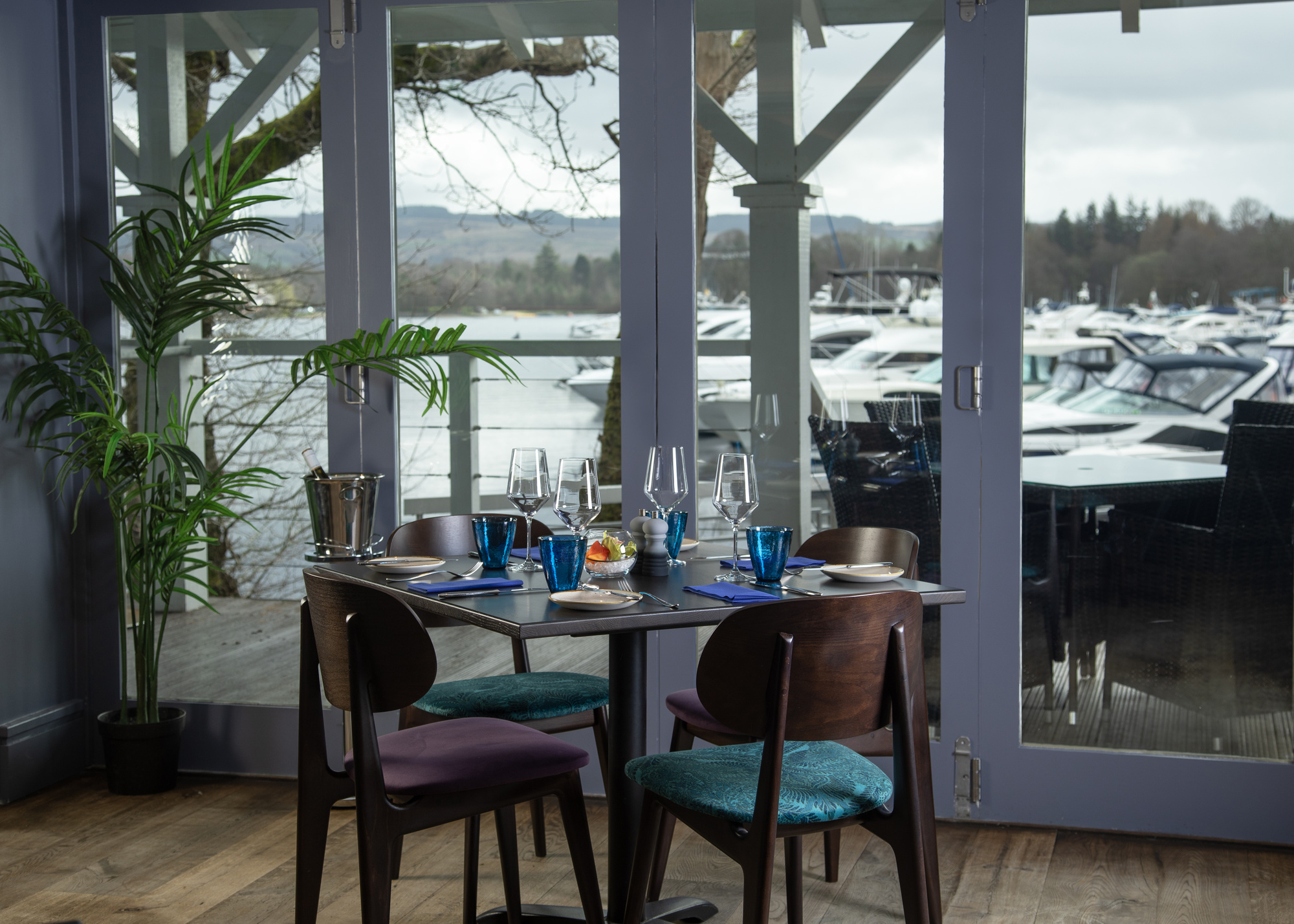 A window view of the marina with a table and four chairs at La Vista restaurant.