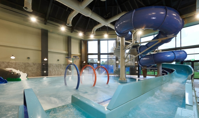 in door swimming pool with large water slide and rings in the middle