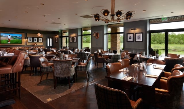 chairs and tables in a dining room with windows showing the outdoor greenery