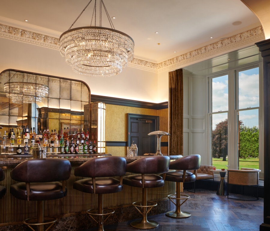 a bar with seating next to a window showing the bright green outside views