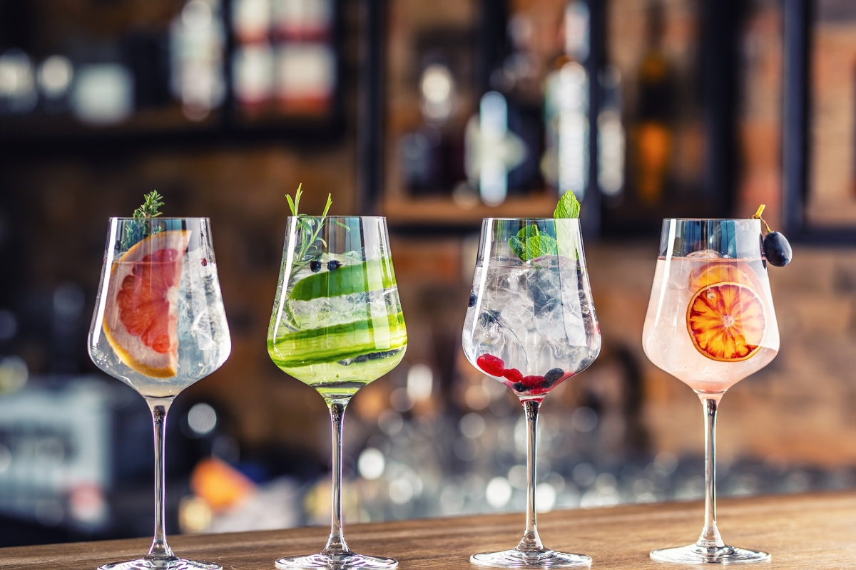 a line up of four cocktails on the counter top of the bar