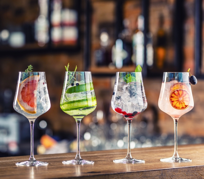 a line up of four cocktails on the counter top of the bar