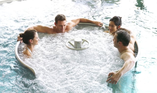 Four friends relaxing in the warm bubble pool at Cameron House Spa