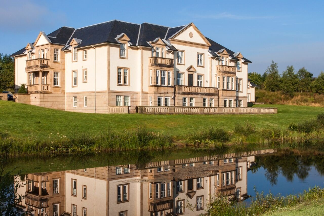 Exterior of Mansion House Suite reflected in a pond