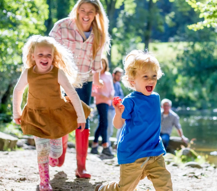 a mother walking outdoors with two children