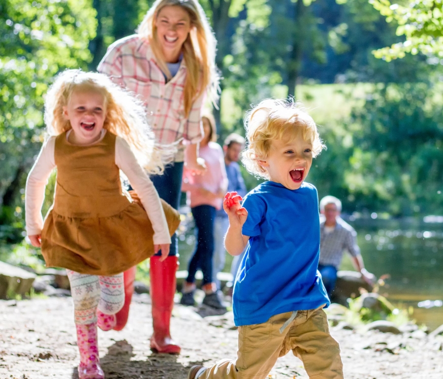 a mother walking outdoors with two children