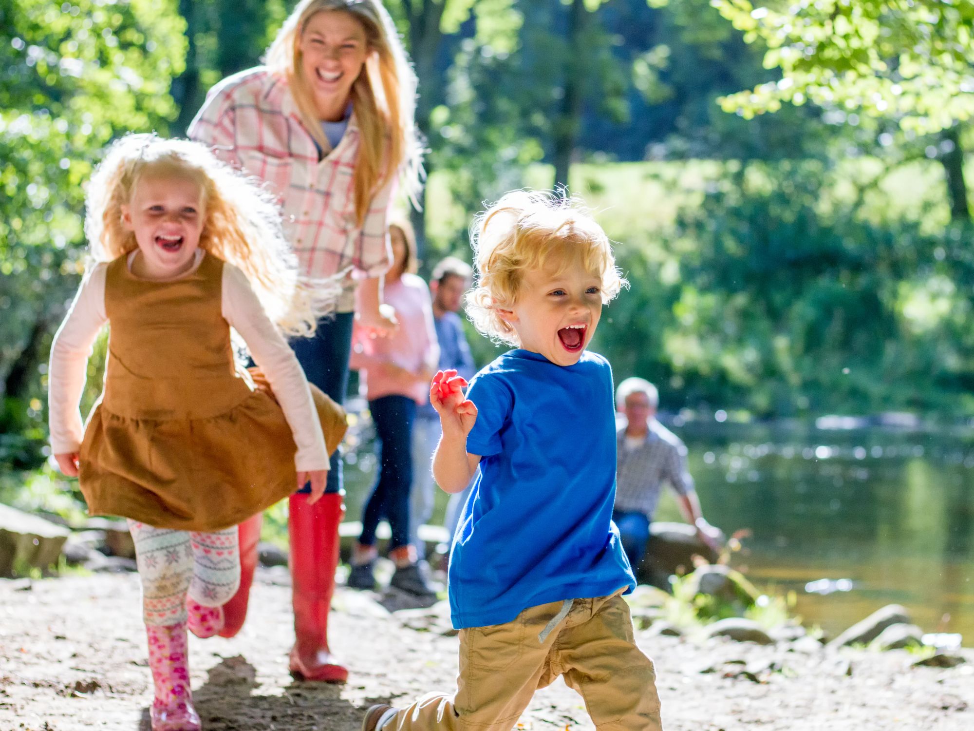 a mother walking outdoors with two children