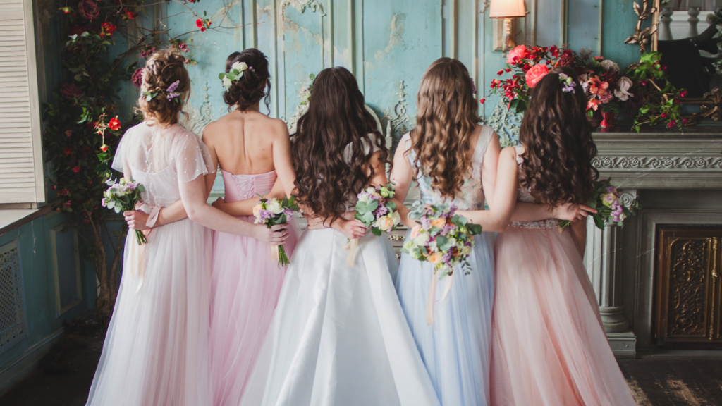 A bride and her bridesmaids with their backs turned. 