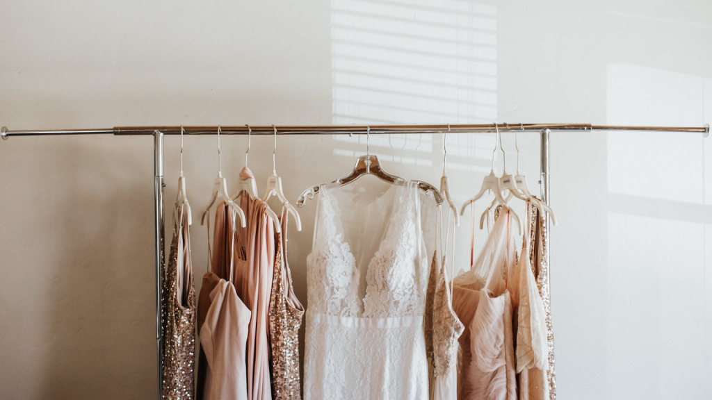 Bride and bridesmaid dresses hanging on a rack. 