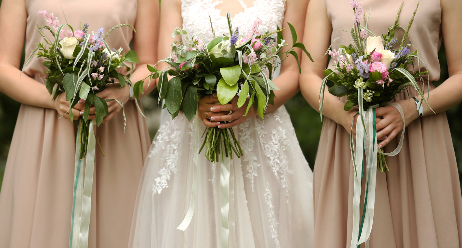 A bride and bridesmaids holding bouquets.