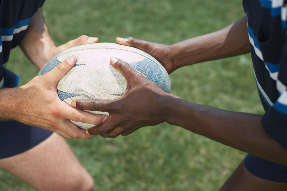 Two people passing rugby ball